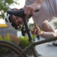 Maarten heeft een fietshelm op en werkt aan zijn zadelpijn door zijn fiets te verstellen in Sliedrecht.