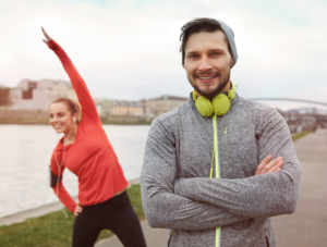 Een vrouw en een man die buiten aan het stretchen zijn als start om te gaan hardlopen omdat zij regelmatig te veel sporten