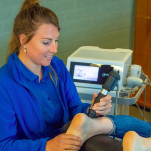 shockwave therapie wordt op de hiel van een patiënt die op de behandelbank ligt